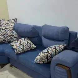 طقم أريكة زرقاء على شكل حرف L مع وسائد